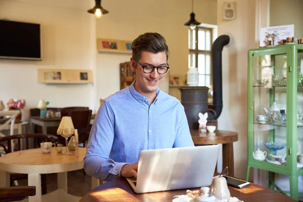 年轻人坐在办公桌前 在咖啡馆里用笔记本电脑时 穿着因果服的肖像照片 小型企业 — 图库照片
