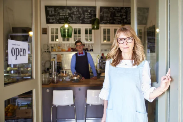 彼女のコーヒーショップで彼女のゲストを待っている間 エプロンを着てあなたに微笑む中年の中小企業のオーナーの女性のショット ファミリービジネス — ストック写真