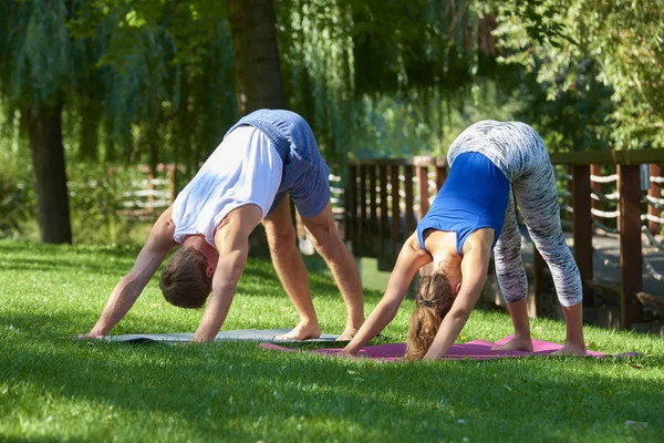 Lachend koppel doet yoga oefeningen buitenshuis — Stockfoto