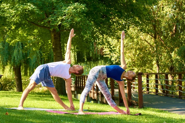 Lachend stel doet yoga oefeningen buiten — Stockfoto