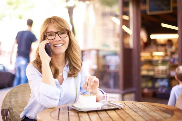 Aufnahme einer Frau mittleren Alters, die in einem Café sitzt und — Stockfoto