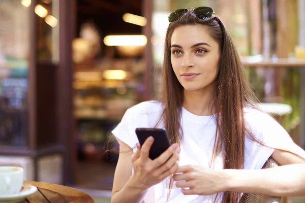 Portrait of young woman sitting in cafe and text messaging — Stock Photo, Image