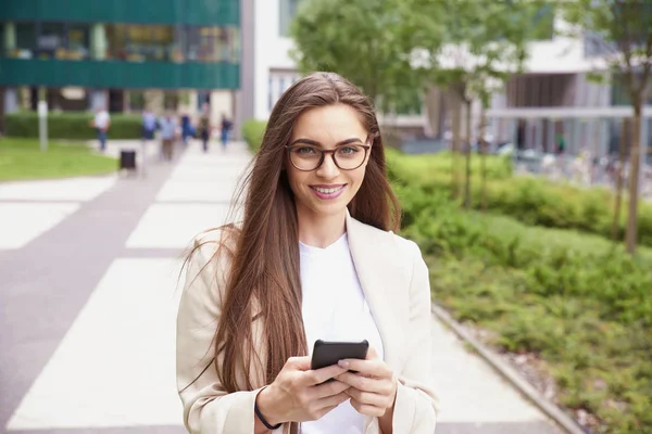 Молода бізнес-леді дзвонить під час прогулянки на вулиці — стокове фото