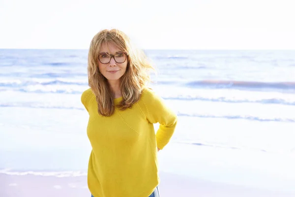 해변에서 휴식을 취하면서 스웨터와 청바지를 아름다운 여성의 초상화 — 스톡 사진