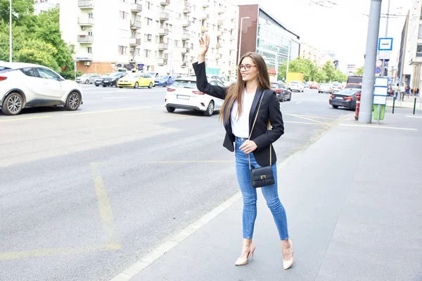 Täyspitkä Laukaus Nuori Nainen Odottaa Taksia Kadulla Kaupungissa — kuvapankkivalokuva