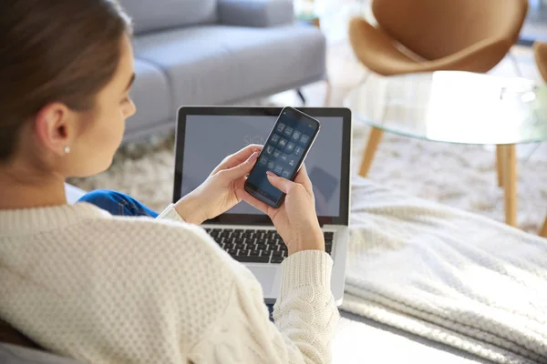 Постріл Молодої Жінки Використовуючи Мобільний Телефон Ноутбук Сидячи Дивані Вдома — стокове фото