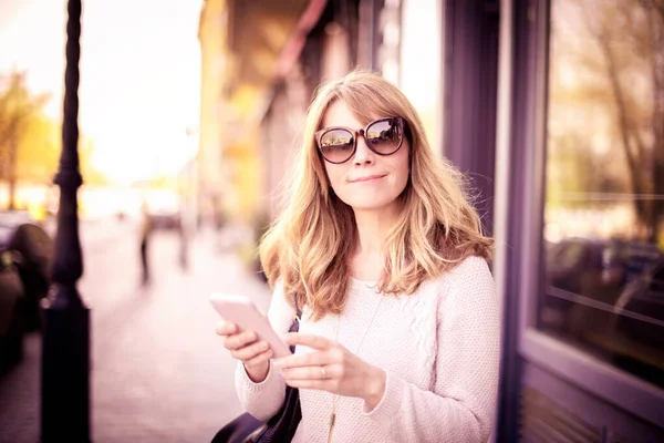 在城市街道上散步时 拍下的成熟女人微笑发短信的特写 — 图库照片