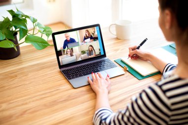 Bilgisayarının arkasında oturup sohbet eden ve kolajlarıyla görüntülü görüşme yapan bir kadın. Evden çalışan bir iş kadını. Merkez Ofis.