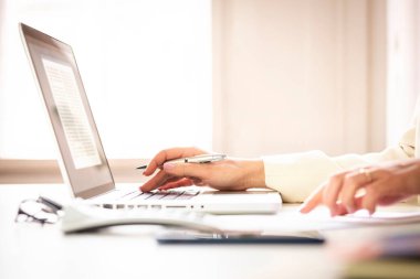 İş kadınının laptopta yazı yazarken ve ofis masasında çalışırken hesap makinesi kullanırken yakın plan görüntüsü. Merkez Ofis. 