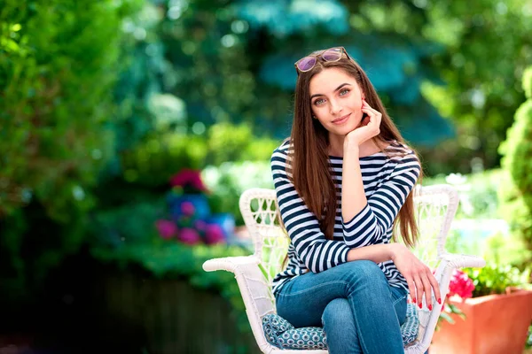 一个迷人的微笑的年轻女子坐在花园里放松的画像 — 图库照片
