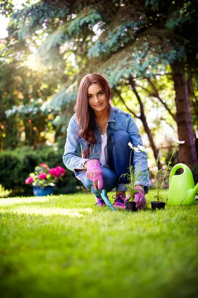 裏庭の自宅で若い女性の園芸の完全な長さのショット 花を植えながらカジュアルな服を着た幸せな女性 — ストック写真