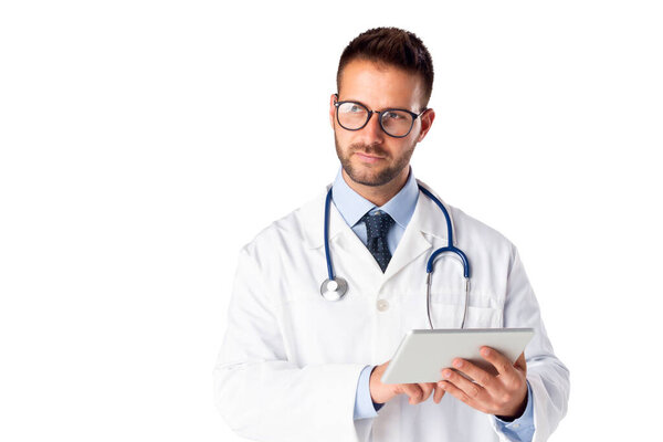 Studio shot of male doctor using digital tablet while standing at isolated white background. Copy space.