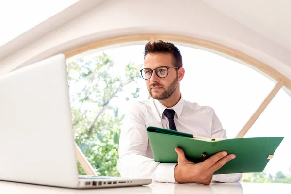 Szczęśliwy Biznesmen Piszący Segregatorze Korzystający Laptopa Siedząc Przy Biurku Biurze — Zdjęcie stockowe