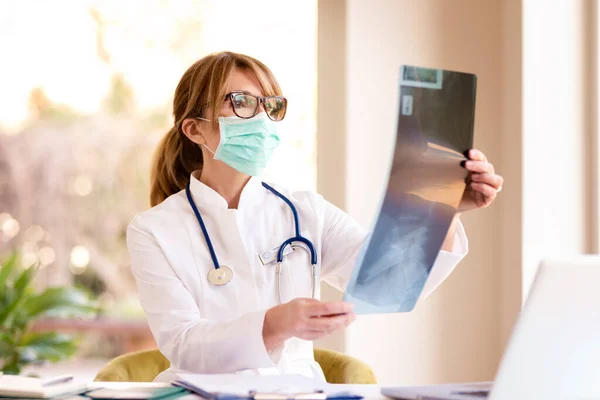 Tiro Médico Feminino Usando Máscara Facial Enquanto Segurando Uma Imagem — Fotografia de Stock