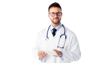 Stüdyoda, beyaz arka planda dikilirken elinde dijital tablet tutan bir erkek doktorun fotoğrafı. Boşluğu kopyala.