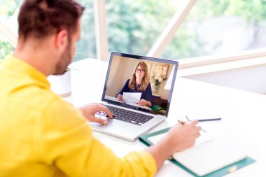 Mutlu iş adamının bilgisayarının başında oturup tartışırken ve internetten görüşürken görüntüsü.. 