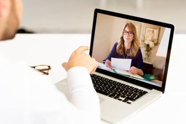 İş adamının dizüstü bilgisayarının arkasında otururken görüntüsü ve görüntülü görüşme.. 