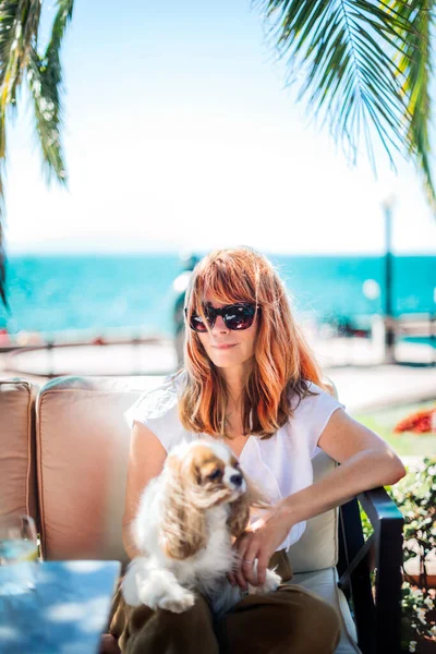 Orta yaşlı bir kadının kralı Charles Cavalier ile deniz kenarında rahatladığı bir fotoğraf.. 