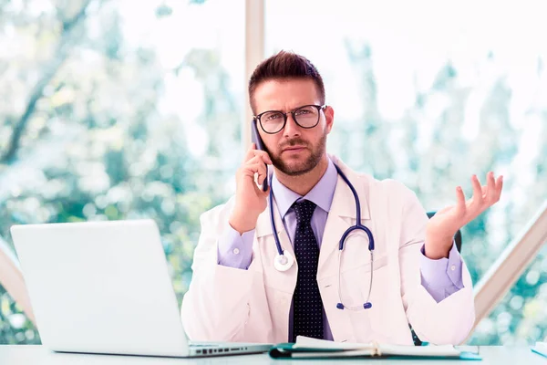 Prise Vue Médecin Assis Bureau Derrière Son Ordinateur Portable Parlant — Photo