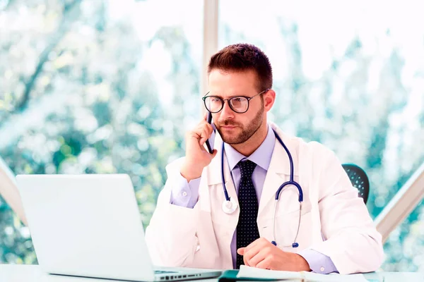 Retrato Médico Varón Desgastado Sentado Detrás Portátil Hablando Por Teléfono — Foto de Stock