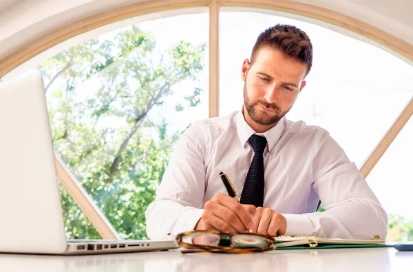 Bonito Homem Negócios Sentado Mesa Escritório Pela Janela Fazendo Alguma — Fotografia de Stock