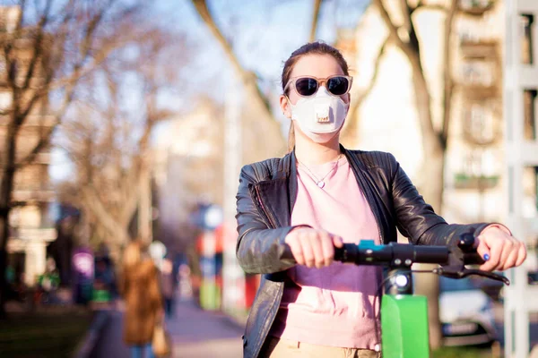 在科罗纳韦病毒大流行期间 在城市骑电动车时被枪杀的年轻女子戴着面具 — 图库照片