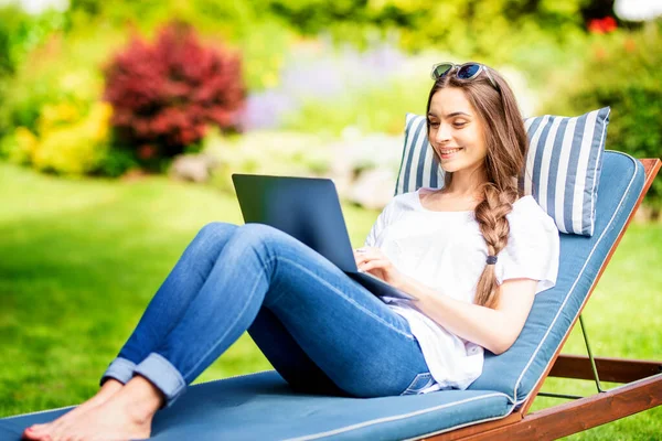 Shot Van Lachende Jonge Vrouw Zitten Zonnebank Tuin Met Behulp — Stockfoto