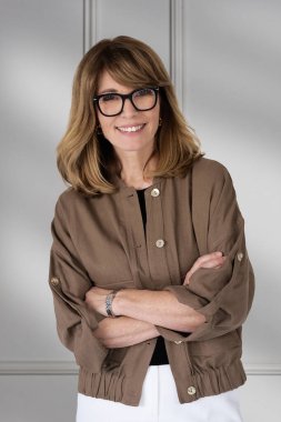 Sarışın kadın, izole edilmiş arka planda duruyor ve kameraya bakıyor. Orta yaşlı kadın iş kıyafeti giyiyor. Boşluğu kopyala. 