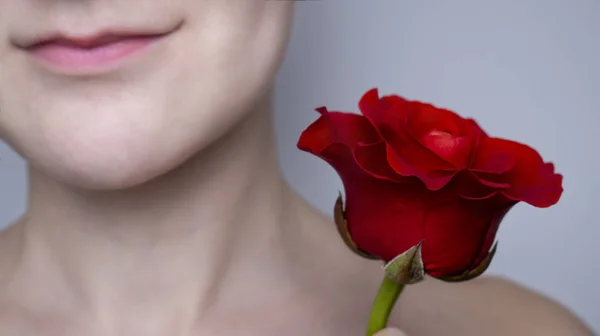 Caucasian girl with red rose. Female face without makeup. Natural beauty.