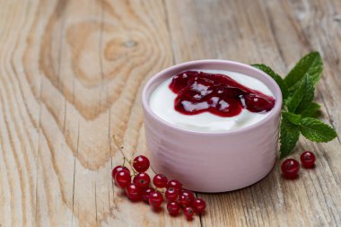 Redcurrants ahşap arka plan üzerinde bir kase ile kırmızı meyve jöle.
