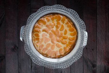 Maun ahşap zemin üzerine mandalina ile kremalı pasta.