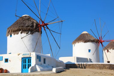 Casa blanca en Santorini con molino y techo de paja