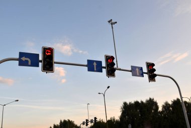 Kentin mavi gökyüzü üzerinde kırmızı trafik ışıkları