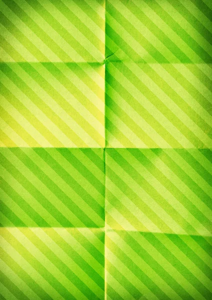 Opgevouwen diagonaal gestreept papier. Groene achtergrond — Stockfoto