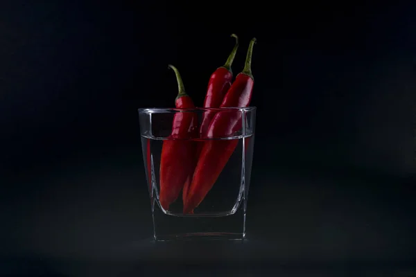 Czerwone papryczki chili w szkle odizolowane na czarno — Zdjęcie stockowe