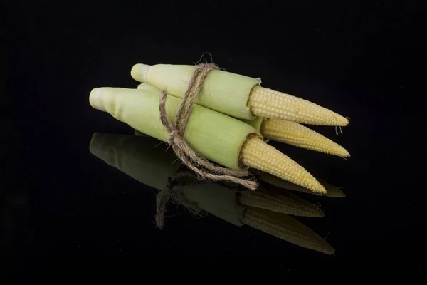 Young raw baby corn isolated on black background — Stock Photo, Image