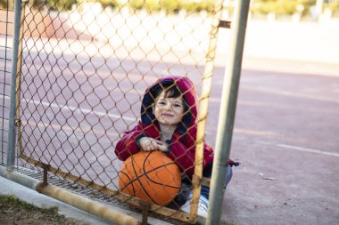 Küçük çocuk basketbol sahasına oynarken