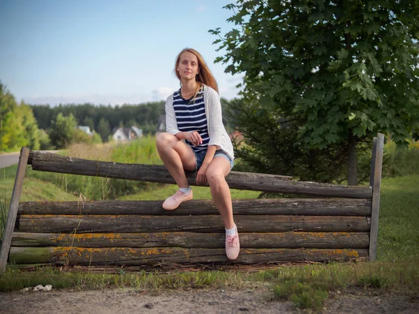 Belleza chica rubia posando en una vieja cerca de madera —  Fotos de Stock