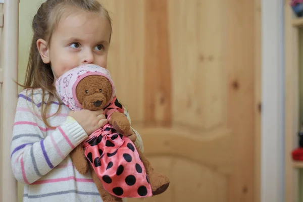 Sonriente niña sosteniendo oso de peluche en el interior — Foto de Stock