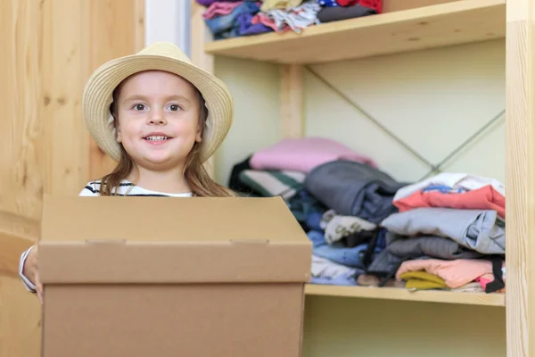 Feliz niña sonriente está sosteniendo caja de cartón — Foto de Stock