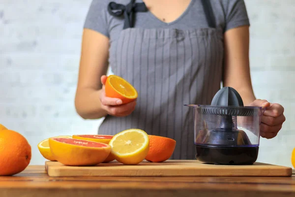 Kvinnan gör apelsinjuice — Stockfoto