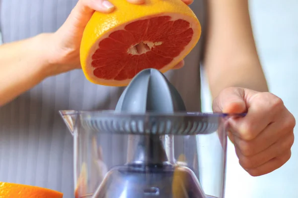Woman is making grapefruit juice — Stock Photo, Image