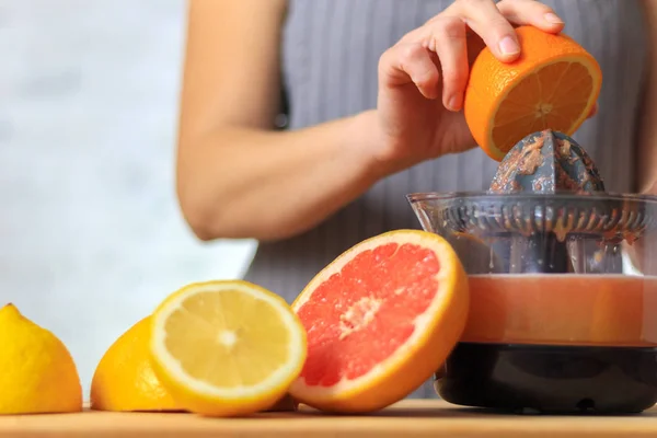 Woman is making orange juice — Stock Photo, Image