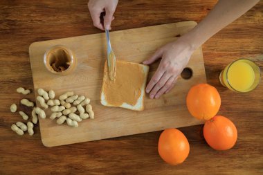 Kadın, sağlıklı kahvaltı hazırlamak, fıstık ezmesi ile sandviç yapmak