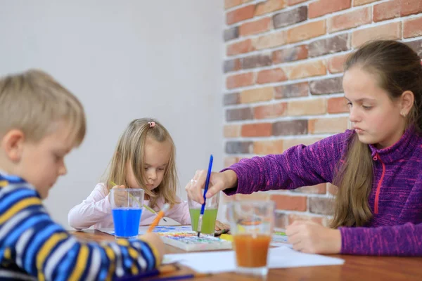 Grupo de niños lindos de una familia está pintando en el papel sentado juntos — Foto de Stock