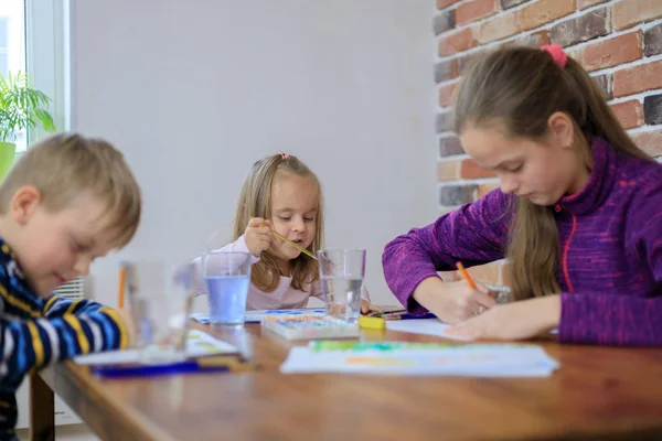 Grupo de niños lindos de una familia está pintando en el papel sentado juntos — Foto de Stock