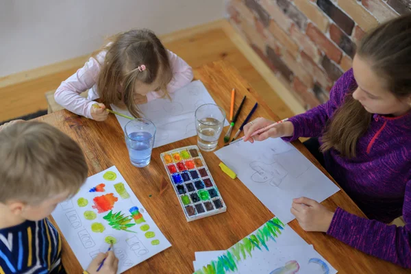 Niños felices - niño y dos niñas está dibujando con pintura de colores — Foto de Stock