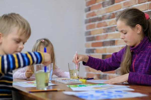 Niños felices - niño y dos niñas está dibujando con pintura de colores — Foto de Stock