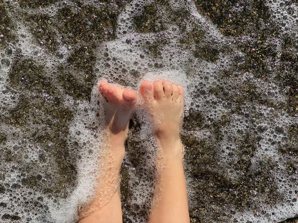 Gambe bambino in mare onde spruzzi — Foto Stock