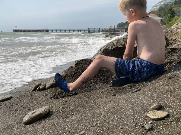 Un ragazzino in costume da bagno sta giocando sulla spiaggia . — Foto Stock